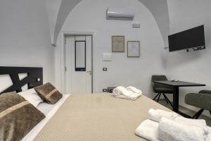 a bedroom with a bed with a desk and a television at Agrù - Salento Garden Stay in Cavallino di Lecce
