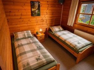 a room with two beds in a log cabin at Ferienwohnungen Forellengrund Schierke in Schierke