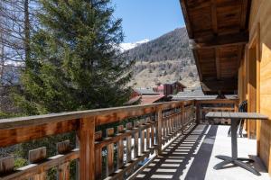 a balcony of a cabin with a picnic table on it at Ferienwohnung Loipenblick in Obergesteln +9 photos