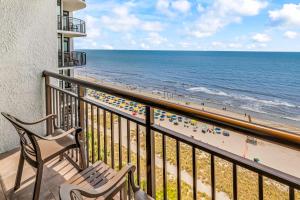 a balcony with a bench and the beach at Condos at the Caribbean Resort in Myrtle Beach