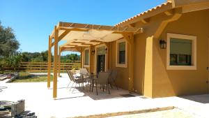 a patio with a table and chairs under a pergola at Villa Mareta in Svoronata