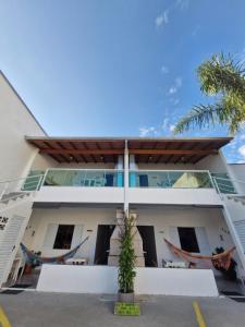 a building with hammocks in front of it at A VER O MAR FLATS in Caraguatatuba