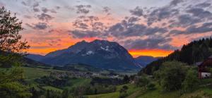 a mountain with a town in a valley at sunset at Haus Weisl in Erlsberg