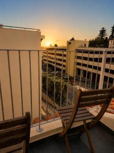 a bench on a balcony with a view of a city at Social Lodge Happiness Studios in Funchal