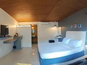 a small bedroom with a bed and a television at KuadKhonThoe Pai Cottage in Pai