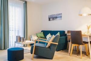 a living room with a blue couch and a table at Am Park 3 in Prerow