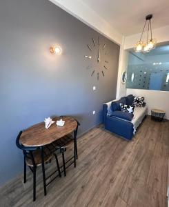 a living room with a table and a couch and a clock at Kova2 in Alexandroupoli