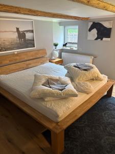 a bedroom with a large wooden bed with two pillows at Allenberghütte Schoningen in Uslar