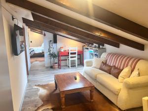 a living room with a couch and a table at Cozy Alpine Attic in Savièse