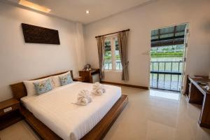 a bedroom with a bed with towels on it at Kenikar Raintree Resort Chumphon in Chumphon +99 photos