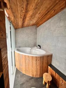 a bath tub in a bathroom with a wooden ceiling at Cozy Alpine Attic in Savièse