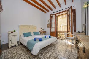 a bedroom with a large bed with blue pillows at Casa Angels in Pollença