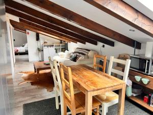 a dining room with a table and a couch at Cozy Alpine Attic in Savièse