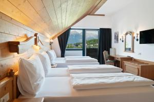 a row of white beds in a room at Hotel Gruberhof Innsbruck Igls B&B in Innsbruck