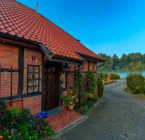 a red brick house with a door and flowers at Steins Hof in Suderburg