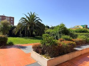 a garden with palm trees and plants on a sidewalk at West Florence in Campi Bisenzio