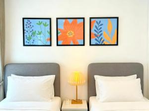 two beds with four pictures above them in a bedroom at Sleep Walker Poshtel in Chiang Mai +84 photos