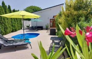 a patio with an umbrella and chairs and a pool at Village Premium Apartment by Český Krumlov Adults Only in Střížov