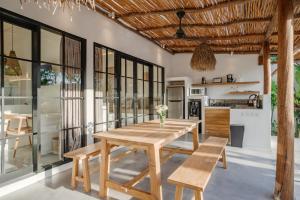 a kitchen and dining room with a wooden table and chairs at Villa Ruta I - Sumptuous 2BR Luxury Villa next to Luna Beach Club and Nyanyi Beach in Tanah Lot