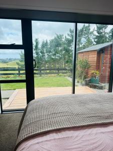 a bedroom with a bed and a large glass window at Views on King in Egmont Village