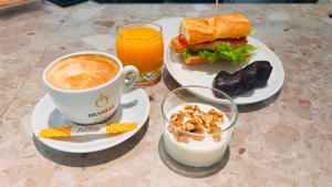 a table with a cup of coffee and a sandwich at U-Hotel Boutique Oria in Tolosa