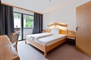 a hotel room with a bed and a window at Hotel Gruberhof Innsbruck Igls B&B in Innsbruck +103 photos