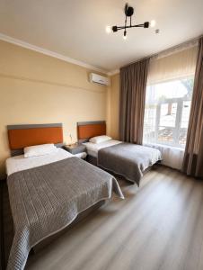 a hotel room with two beds and a window at All residence in Almaty