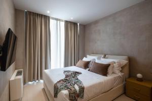 a bedroom with a large bed with a bow tie on it at Nomade Villas in Agios Ioannis Peristerion +86 photos