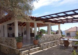 a patio of a house with a stone wall at Seafront House, Private Beach, Sunset View, Diliso in Vathírrevma