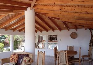 a room with a wooden ceiling and a table and chairs at Seafront House, Private Beach, Sunset View, Diliso in Vathírrevma