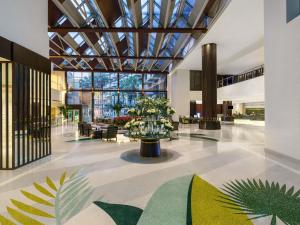 a lobby with a large glass ceiling with plants at Rixos The Palm Hotel & Suites - Ultra All Inclusive in Dubai