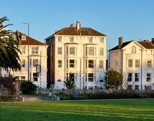 a large white building with a grass field in front at Stylish Top Floor Retreat with Stunning Solent Views in Portsmouth