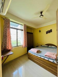 a bedroom with a bed and a large window at Paradise Villa in Siliguri