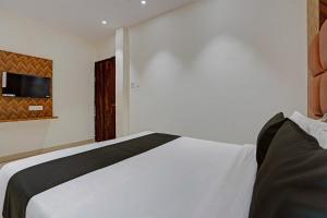 a bedroom with a white bed and a tv on the wall at Hotel O Skycity in Kānpur