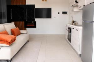 a living room with a white couch and a kitchen at GM House - Appartamento luminoso con grande terrazza vicino Torino in Collegno