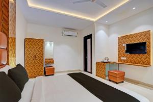 a bedroom with a bed and a tv on the wall at Hotel O Skycity in Kānpur +23 photos