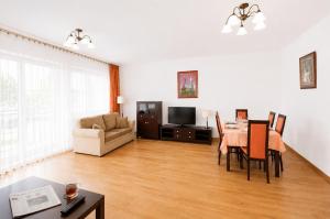 a living room with a table and a dining room at Extra Apartamenty - Apartament przy plaży in Sopot