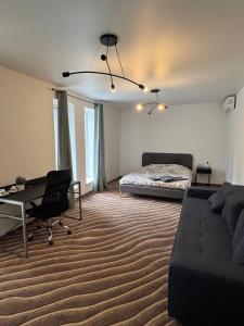 a bedroom with a bed and a desk and a couch at Хрю-хрю in Brovary