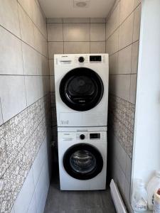 a washing machine and a washer and dryer in a bathroom at Хрю-хрю in Brovary