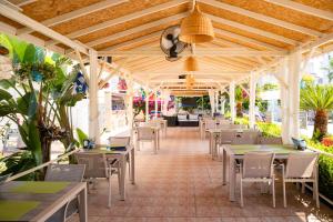an outdoor restaurant with tables and chairs and a ceiling at Nora Suit Hotel in Side