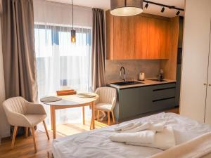 a bedroom with a bed and a table and a kitchen at GERALT Tatras Residence in Nová Lesná
