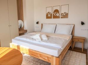 a bed with white sheets and pillows in a room at GERALT Tatras Residence in Nová Lesná