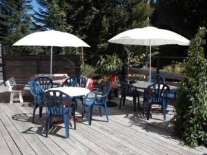 a patio with tables and chairs and umbrellas at Les ateliers du Cucheron in Saint-Pierre-de-Chartreuse
