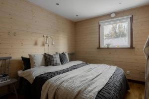 a bedroom with a bed in a wooden wall at Dream view in Åre Björnen in Åre