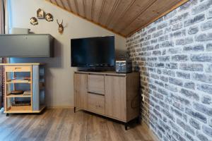 a living room with a tv and a brick wall at Ferienhaus Fanny in Lam