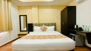 a bedroom with a large bed and a mirror at Hotel Rove Inn in Indore