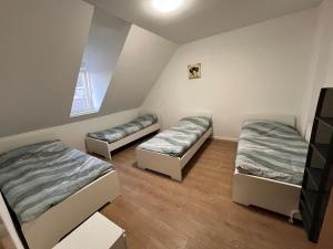 a room with three beds and a window at Avansunterkünfte für Monteure in Hamm