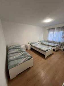 two beds in a room with wooden floors at Avansunterkünfte für Monteure in Hamm