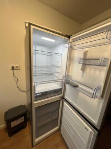 an empty refrigerator with its door open in a kitchen at Avansunterkünfte für Monteure in Hamm