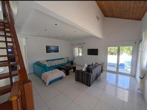 a living room with a blue couch and a tv at Villa Mari in Makris Gialos